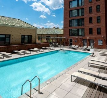 a swimming pool in front of a brick building